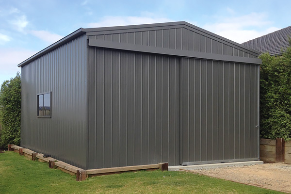 Grey storage shed with steel sliding doors and gable roof