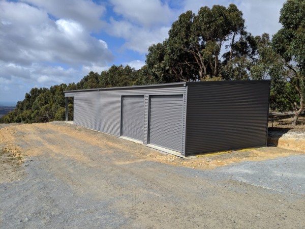Long grey skillion roof shed with two roller doors